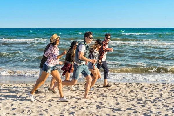 Grupo de jóvenes amigos hipster corriendo por la playa juntos — Foto de Stock