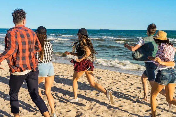 Grupo de jóvenes amigos hipster corriendo por la playa juntos — Foto de Stock