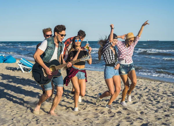 Fiesta en la playa con guitarra. Amigos bailando juntos en la playa — Foto de Stock