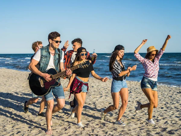 上海滩和他的朋友们在他周围跳舞弹吉他的男人 — 图库照片