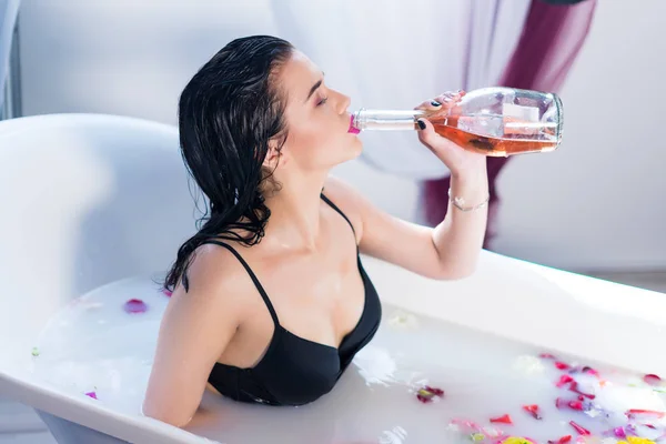 Sexy bruna donna che beve champagne mentre fa il bagno caldo — Foto Stock