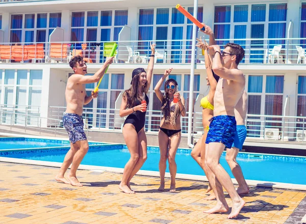 Jovens que parecem felizes dançando na piscina — Fotografia de Stock