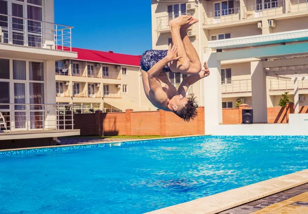 Man doing Somersaul or flip diving into swimming pool