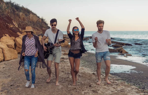 Grupo de amigos jóvenes y alegres caminando en la playa — Foto de Stock