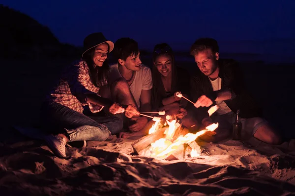 Freunde, die am Strand sitzen, klirren mit Gläsern am Lagerfeuer — Stockfoto