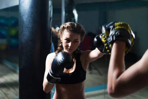 Young fighter boxer fit girl wearing boxing gloves in training
