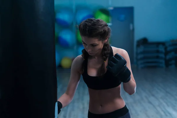 Chica boxeadora joven en entrenamiento con saco de boxeo pesado —  Fotos de Stock