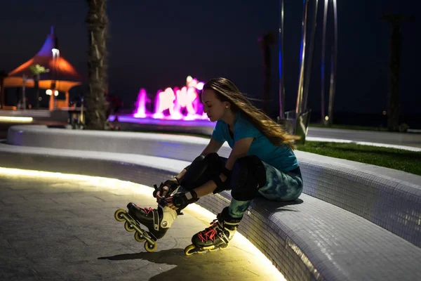 Caucásico chica disfruta de patinaje sobre ruedas en la noche de la ciudad con luces en bokeh — Foto de Stock