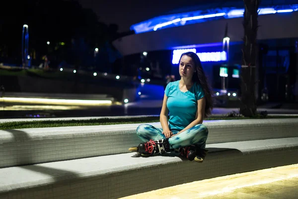 Sports roller girl sitting in a lotus pose after training