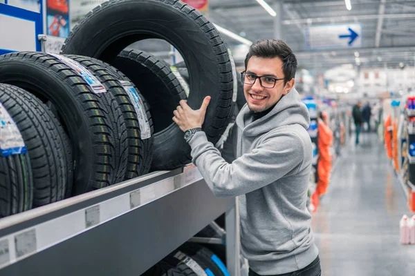 Cliente masculino elegir neumáticos nuevos — Foto de Stock