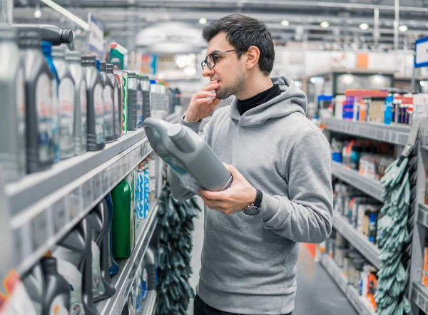 Cliente masculino que compra aceite lubricante del motor en el supermercado del coche — Foto de Stock