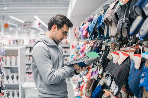 Homem cliente escolhendo chinelos em casa no shopping supermercado — Fotografia de Stock