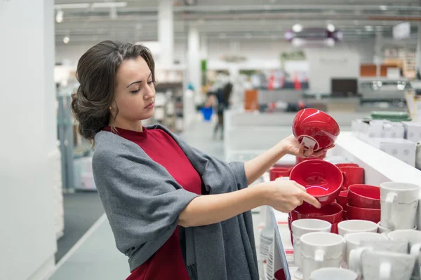 Cliente fêmea escolhendo pratos utensílios no shopping do supermercado — Fotografia de Stock