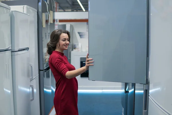 housewife choosing large fridges in domestic appliances section