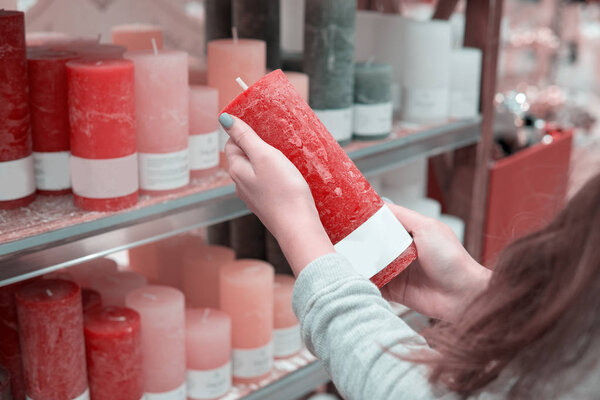 woman hands choosing festive decorative candles for Christmas or New Year