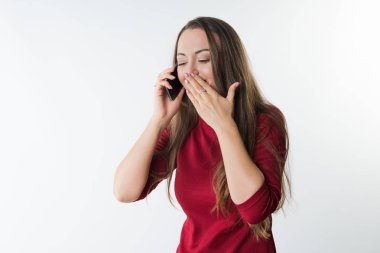 kadın cep telefonu konuşma ve ağzını el ile kapsayan gülüyor