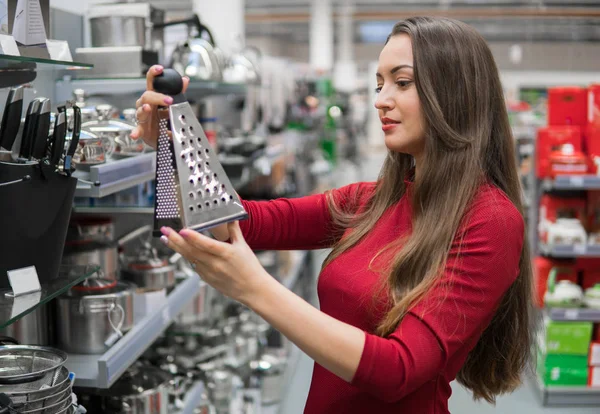 Slimme huisvrouw vrouw koopt keuken rasp in supermarkt. — Stockfoto