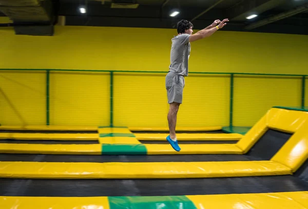 Trampolín jumper realiza ejercicios acrobáticos en el trampolín —  Fotos de Stock