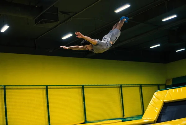 Trampolín jumper realiza ejercicios acrobáticos en el trampolín —  Fotos de Stock