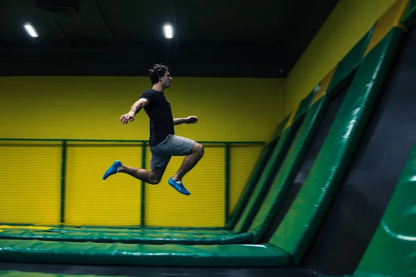 Trampolín jumper realiza ejercicios acrobáticos en el trampolín —  Fotos de Stock