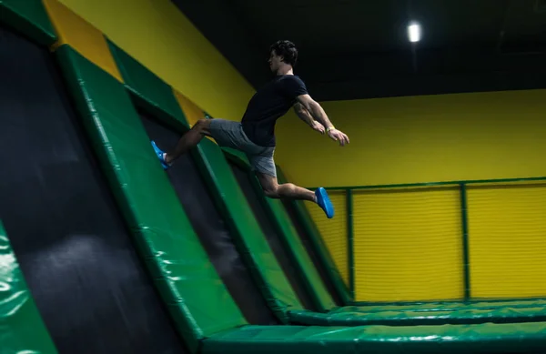 Trampolín jumper realiza ejercicios acrobáticos en el trampolín —  Fotos de Stock