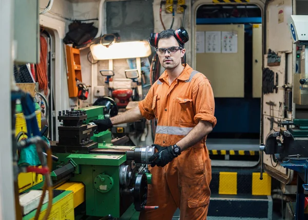 Marine engineer working in ships workshop in engine control room