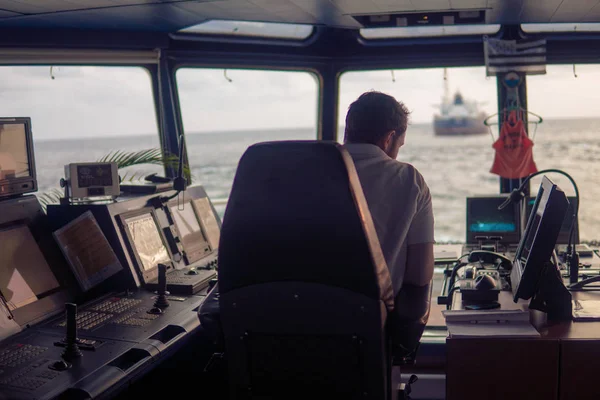 Deck navigation officer on the navigation bridge. He looks at radar screen