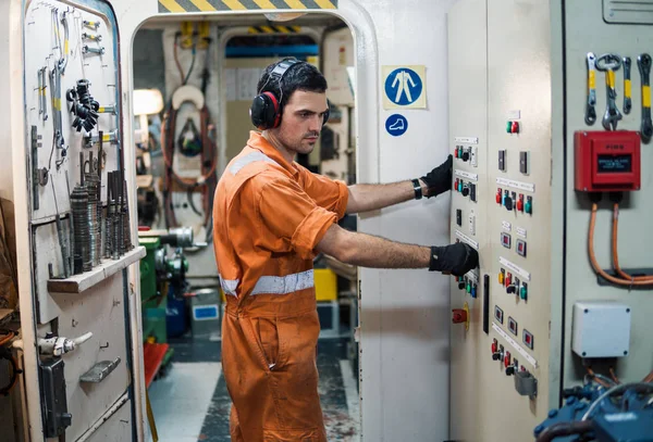 Marine engineer officer controlling vessel engines in engine control room ECR