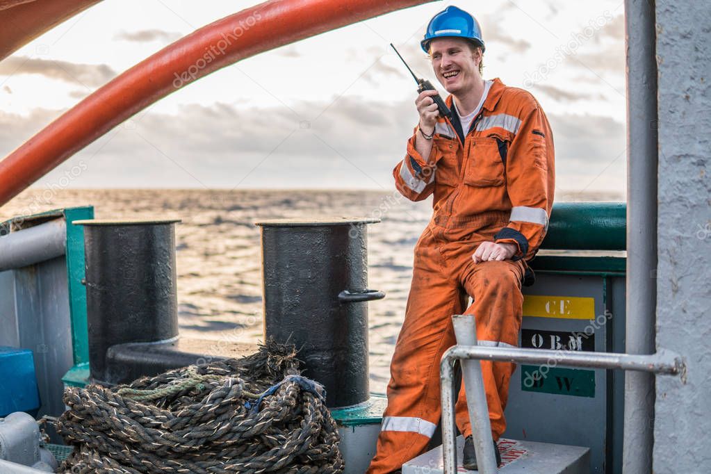 Marine Deck Officer or Chief mate on deck of ship with VHF radio