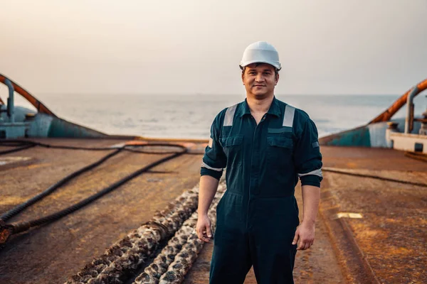 Ufficiale di coperta o ufficiale di coperta sul ponte della nave offshore o della nave, con indosso dispositivi di protezione individuale PPE casco, tuta. Ha in mano la radio walkie-talkie VHF. — Foto Stock