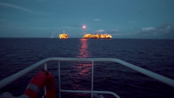 石油掘削プラットフォーム近く Fpso タンカー船。オフショア石油と天然ガス産業。フレアが煙で燃えています。補給船からの眺め — ストック動画