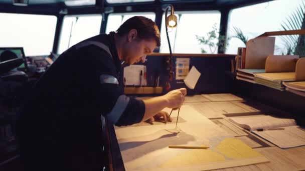 Officier de navigation maritime pendant le quart à la passerelle. Il corrige les graphiques. — Video