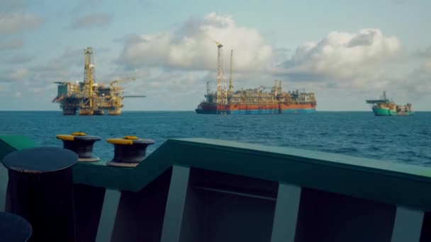 Танкер FPSO рядом с платформой нефтяной вышки. Оффшорная нефтегазовая промышленность. Вспышка горит от дыма. Вид с судна снабжения — стоковое видео