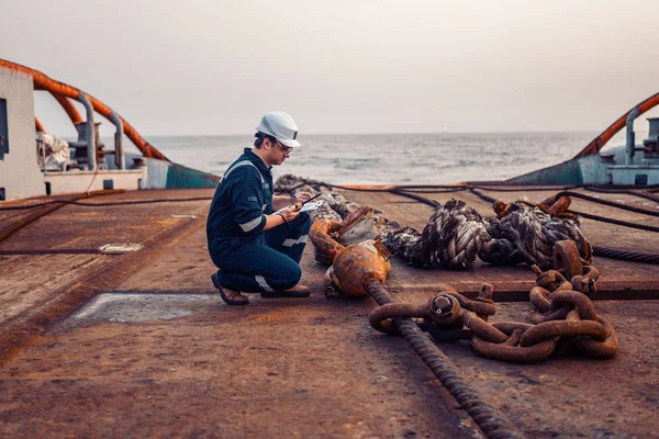 Oficial-chefe da Marinha ou companheiro-chefe no convés do navio ou navio. Ele enche a lista de verificação de naves. Documentação de rotina do navio. Ele segura rádio walkie-talkie VHF nas mãos . — Fotografia de Stock