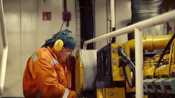 Engenheiro naval que inspeciona o motor dos navios na sala de controle do motor — Vídeo de Stock