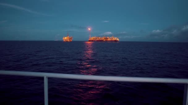 FPSO tankowiec statku w pobliżu platformy wiertniczej. Offshore przemysłu ropy i gazu. Flary jest spalanie z dymem. Widok z dostaw statku — Wideo stockowe