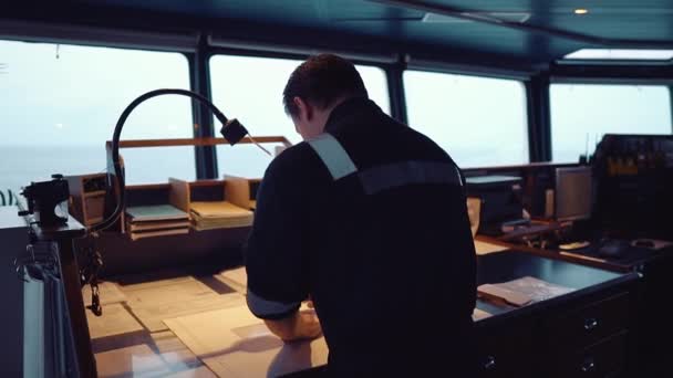 Oficial de navegación de la Marina durante la guardia de navegación en Bridge. Él hace corrección de cartas — Vídeo de stock