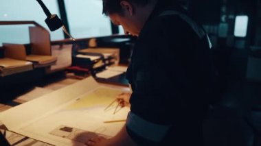 Köprüdeki seyir gözlemi sırasında deniz seyir subayı. Çizelge düzeltmesi yapıyor.