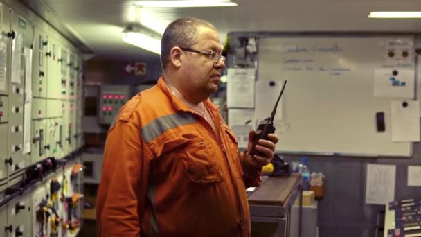 Ingénieur maritime travaillant sur la communication radio à la salle de commande des moteurs — Video