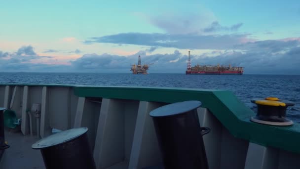 Buque cisterna FPSO cerca de plataforma Oil Rig. Industria petrolera y de gas en alta mar. La bengala arde de humo. Vista desde el buque de suministro — Vídeo de stock