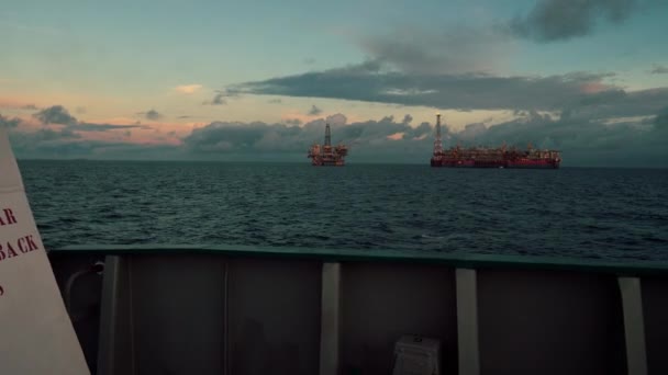 Buque cisterna FPSO cerca de plataforma Oil Rig. Industria petrolera y de gas en alta mar. La bengala arde de humo. Vista desde el buque de suministro — Vídeo de stock