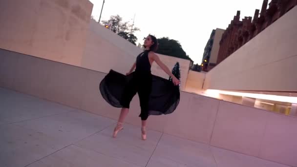 Joven bailarina profesional en vestido negro está bailando al aire libre — Vídeo de stock