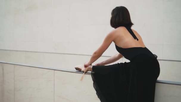 Young professional ballerina in black dress is dancing outdoors — Stock Video