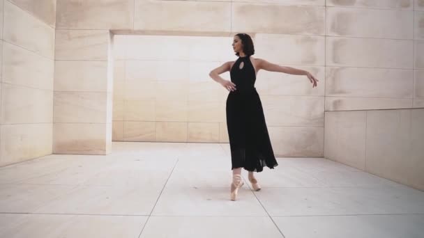 Νεαρή επαγγελματική μπαλαρίνα με μαύρο φόρεμα χορεύει σε εξωτερικούς χώρους — Αρχείο Βίντεο