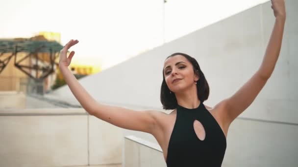 Young professional ballerina in black dress is dancing outdoors — 비디오