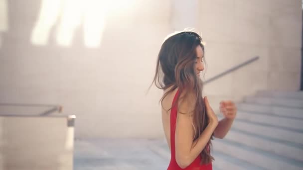 Hermosa mujer en vestido elegante rojo. Fondo blanco urbano — Vídeos de Stock