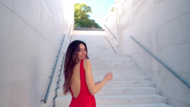 Красива жінка в червоній елегантній сукні. Міський білий фон — стокове відео