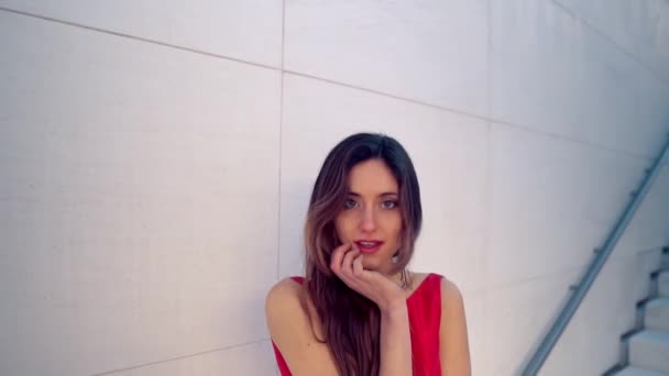 Hermosa mujer en vestido elegante rojo. Fondo blanco urbano — Vídeo de stock