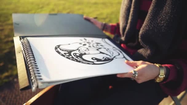 Modern ung snygg manlig målare rita skisser i parken — Stockvideo