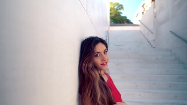 Schöne Frau im roten eleganten Kleid. städtischer weißer Hintergrund — Stockvideo